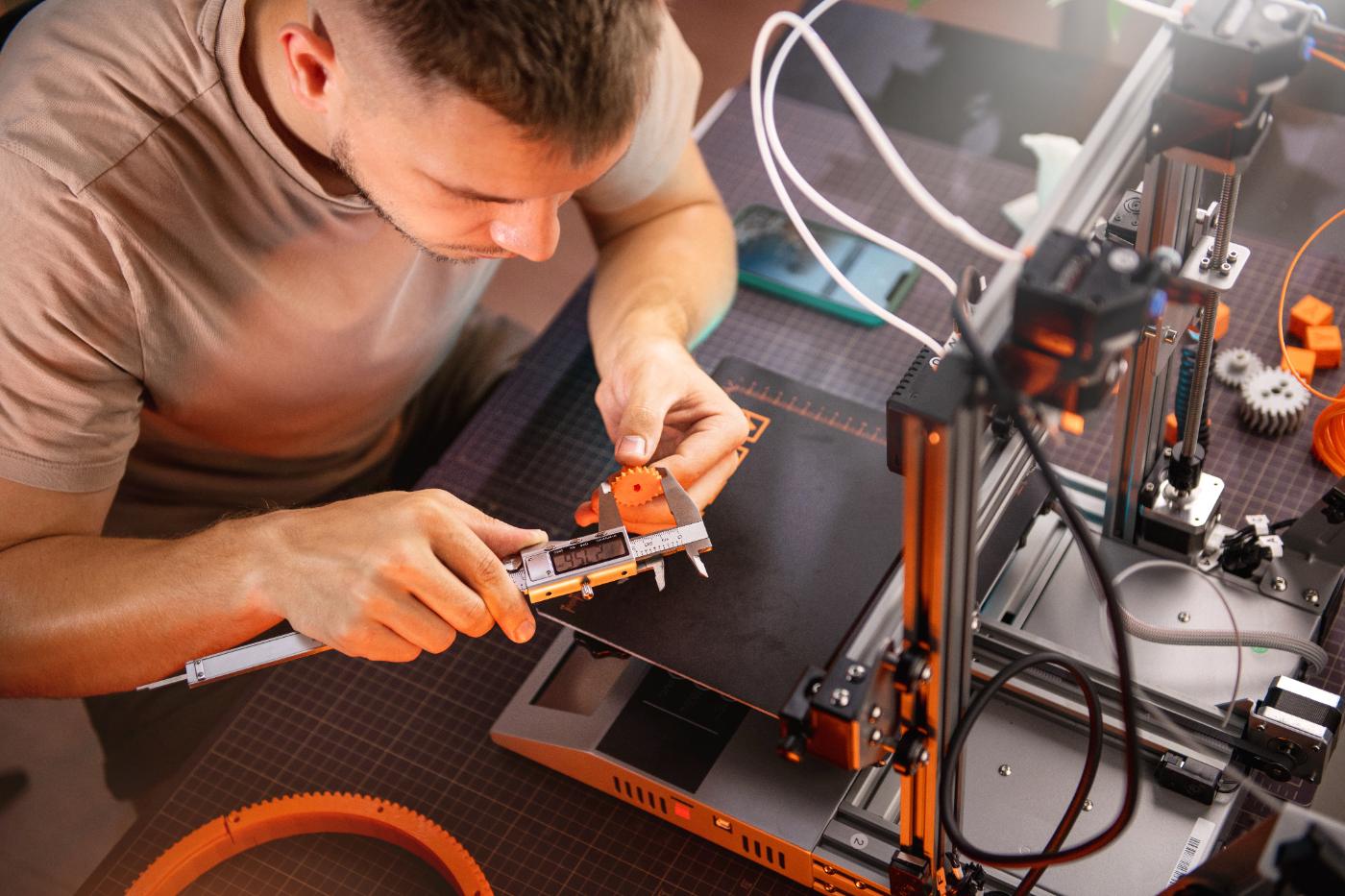 A student measuring a 3D-printed gear with calipers